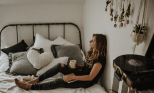 Young woman relaxing in bed with enjoying a cup of coffee