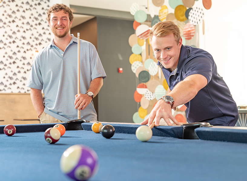 Two young men playing pool