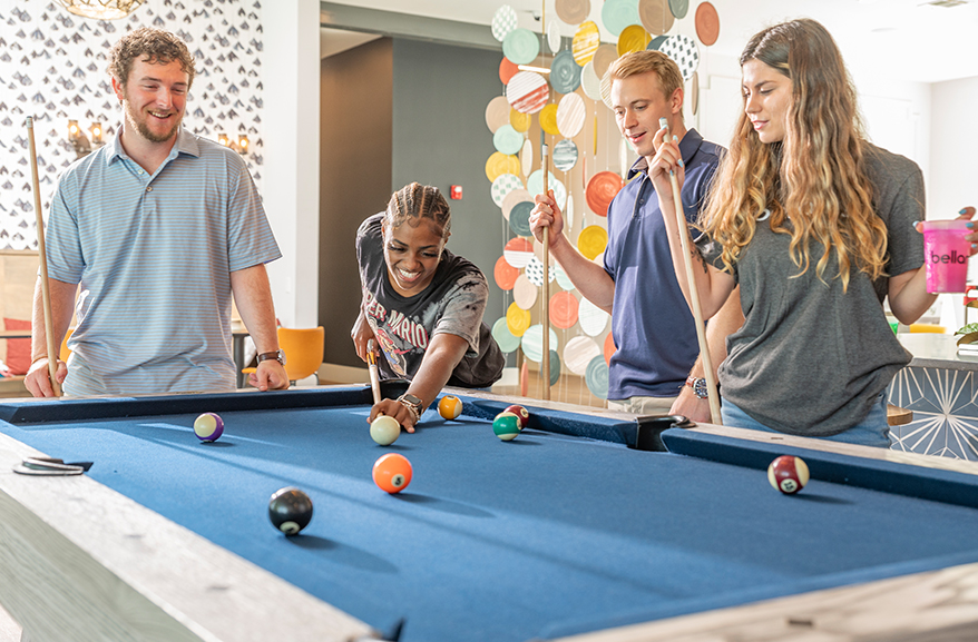 Group of young adults playing pool